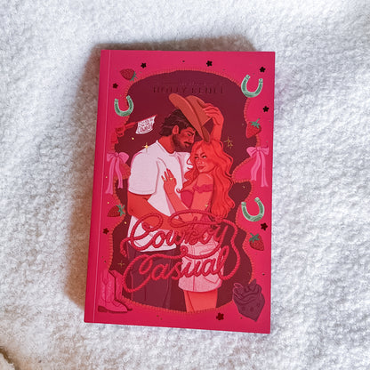 Book titled 'Cowboy Casual' with a red cover featuring illustrations of a couple on a textured white surface.