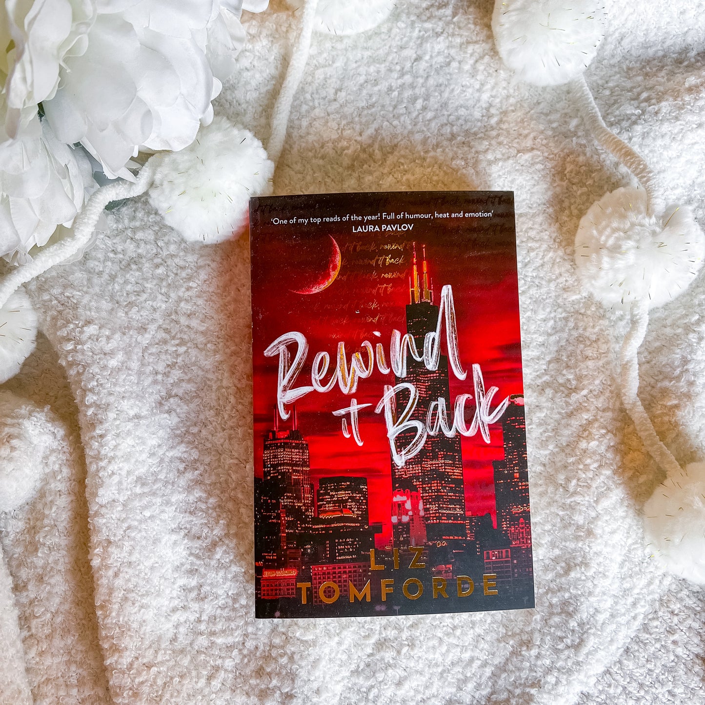 Book titled 'Rewind It Back' by Liz Tomforde on a textured surface with floral elements.