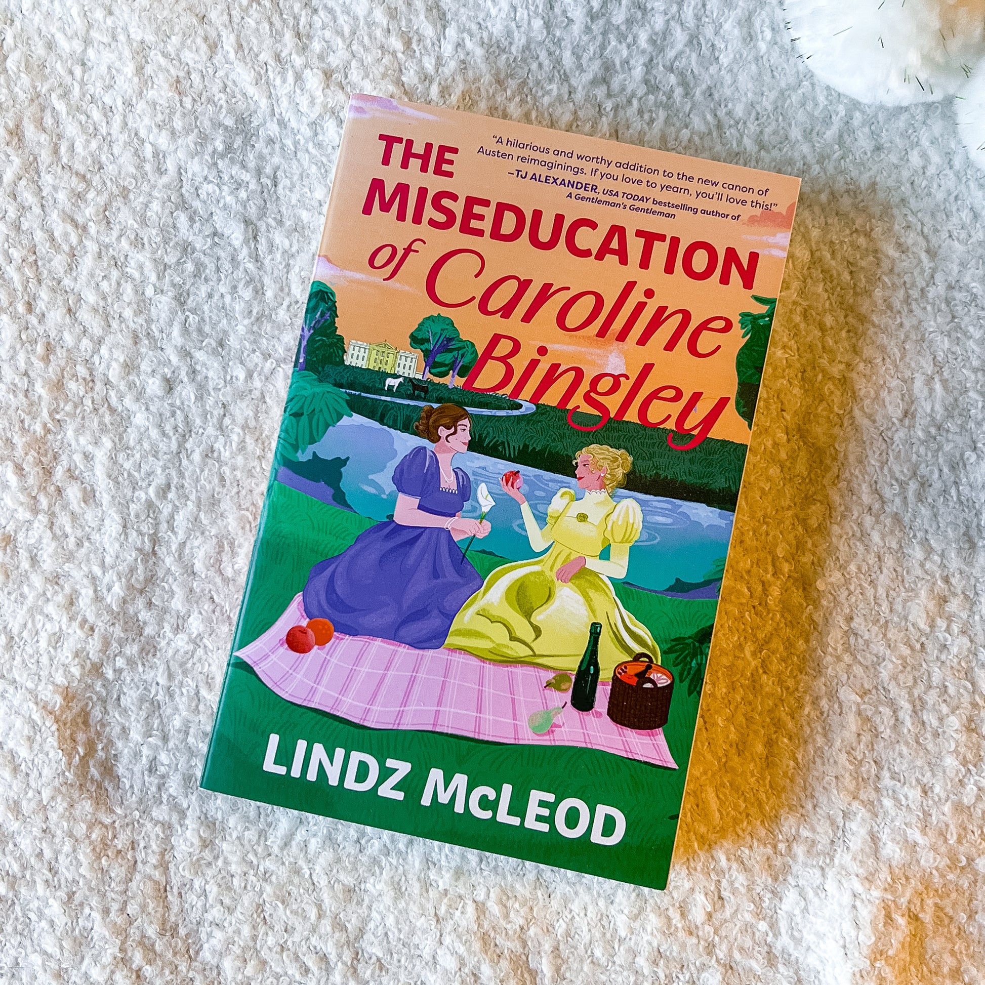 Book titled 'The Miseducation of Caroline Bingley' by Lindz McLeod on a textured surface.