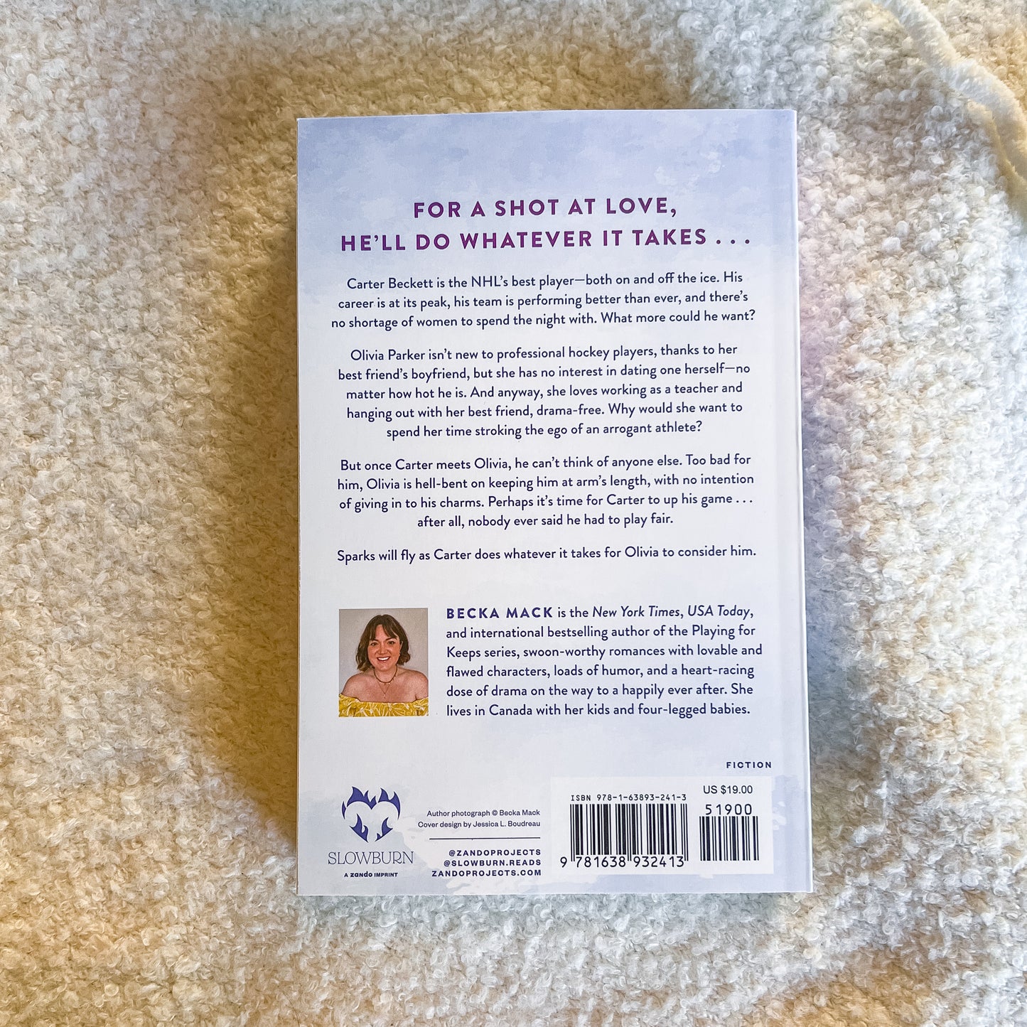 Book back cover with text and author's photo on a textured beige surface