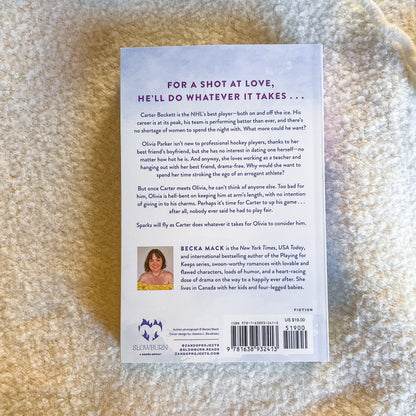 Book back cover with text and author's photo on a textured beige surface