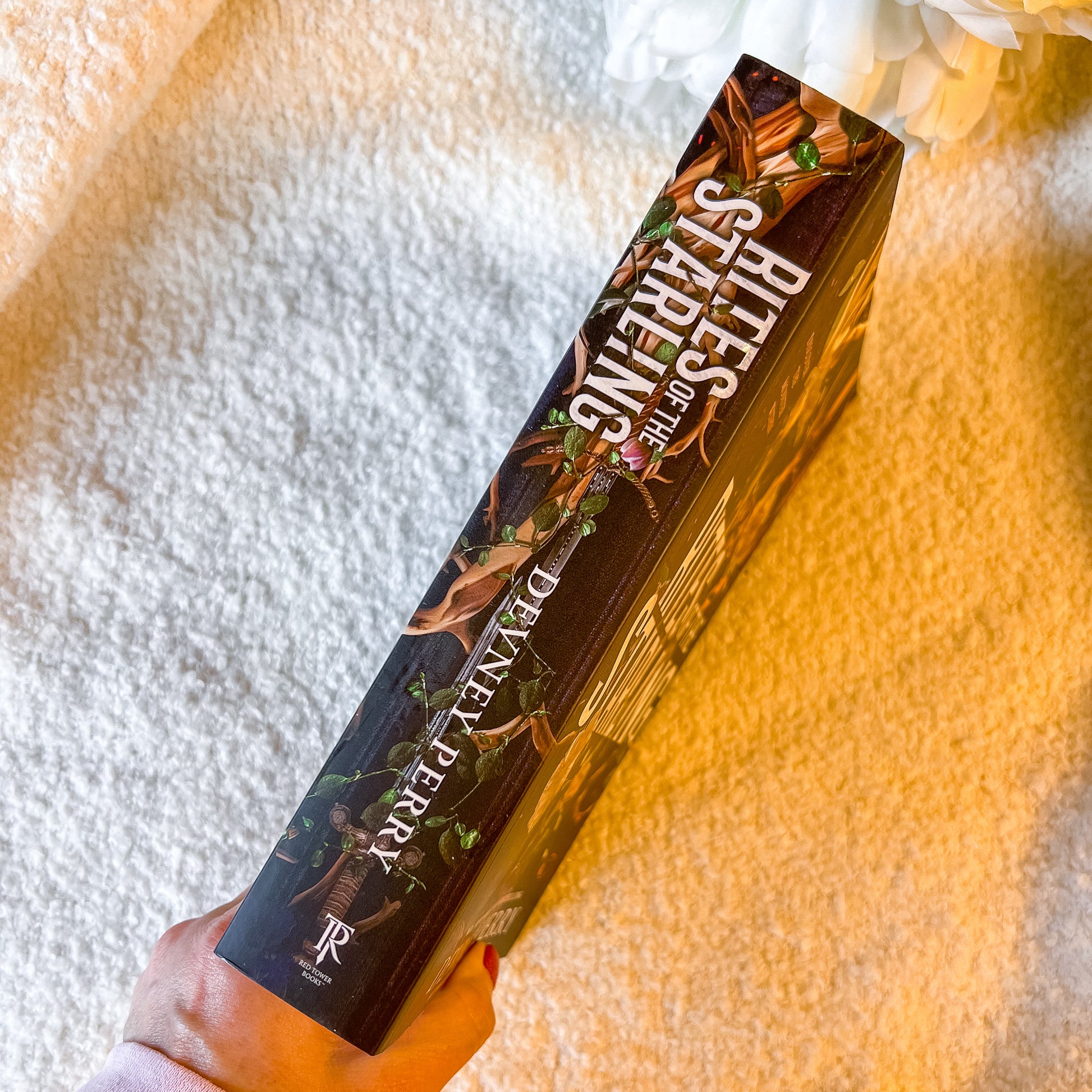 The spine of the book "Rites of the Starling" on a textured white surface.