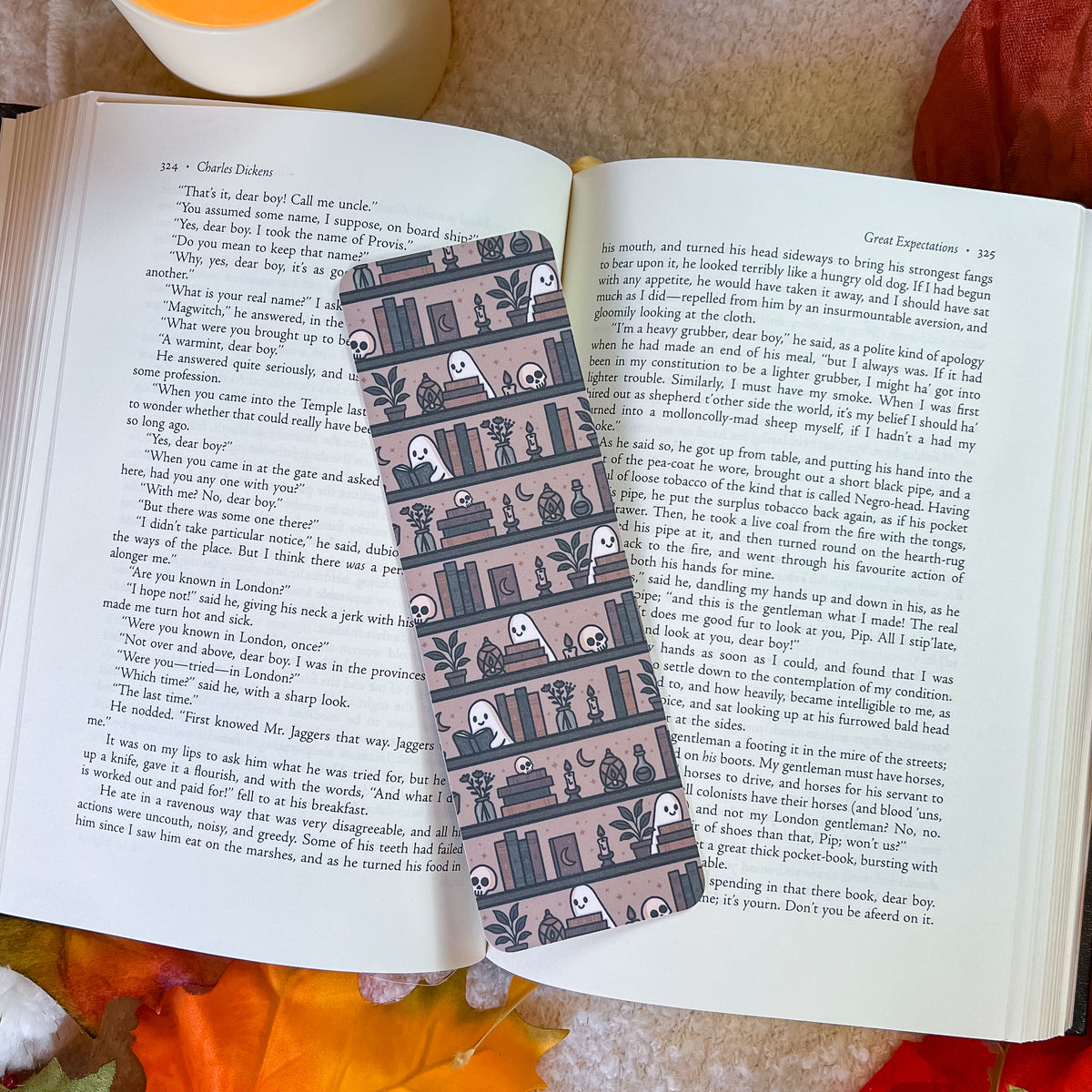 A book-themed bookmark, displayed on an open book with a cozy brown blanket underneath.