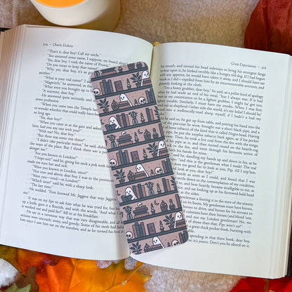 A book-themed bookmark, displayed on an open book with a cozy brown blanket underneath.