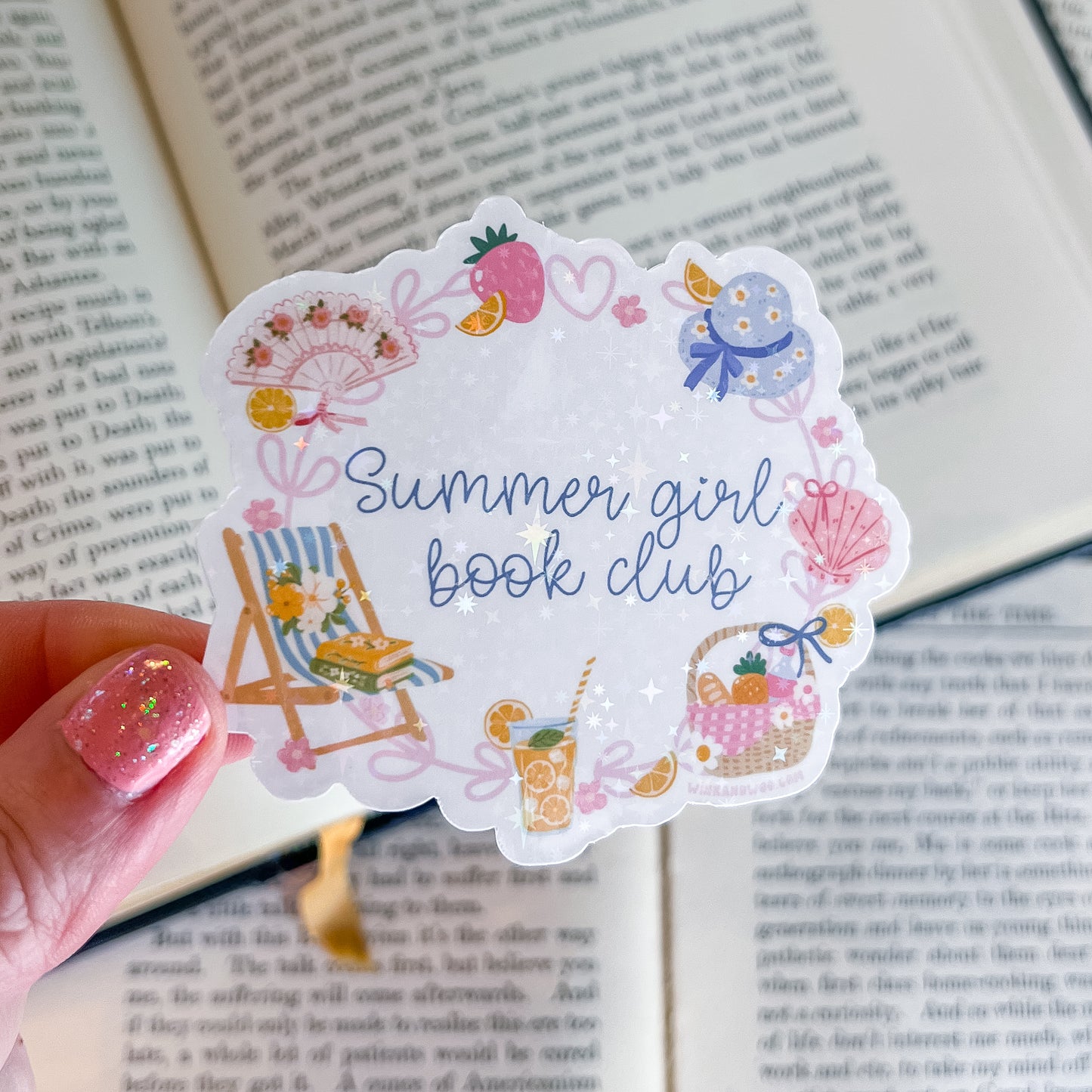 Sticker with 'Summer girl book club' text held over an open book