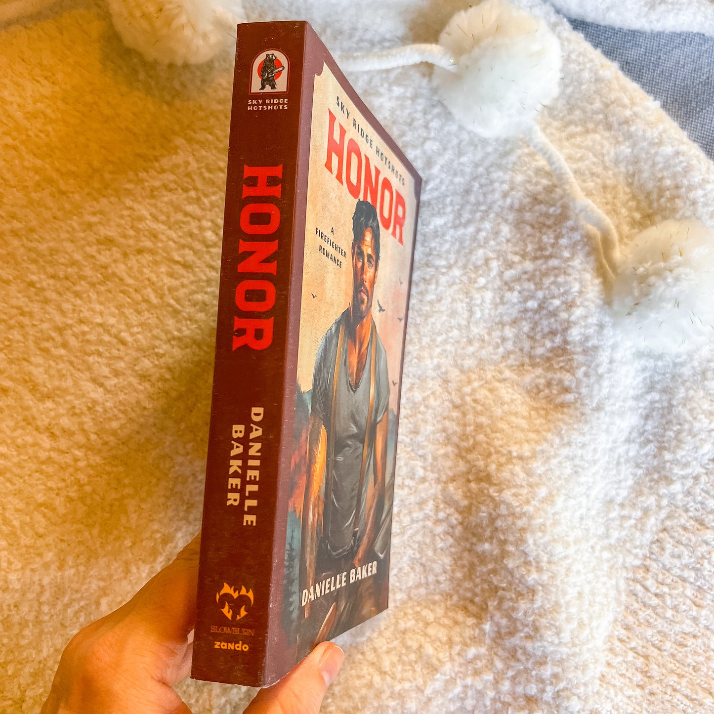 Book titled 'Honor' by Danielle Baker held against a textured beige background