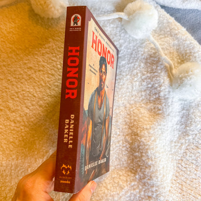 Book titled 'Honor' by Danielle Baker held against a textured beige background
