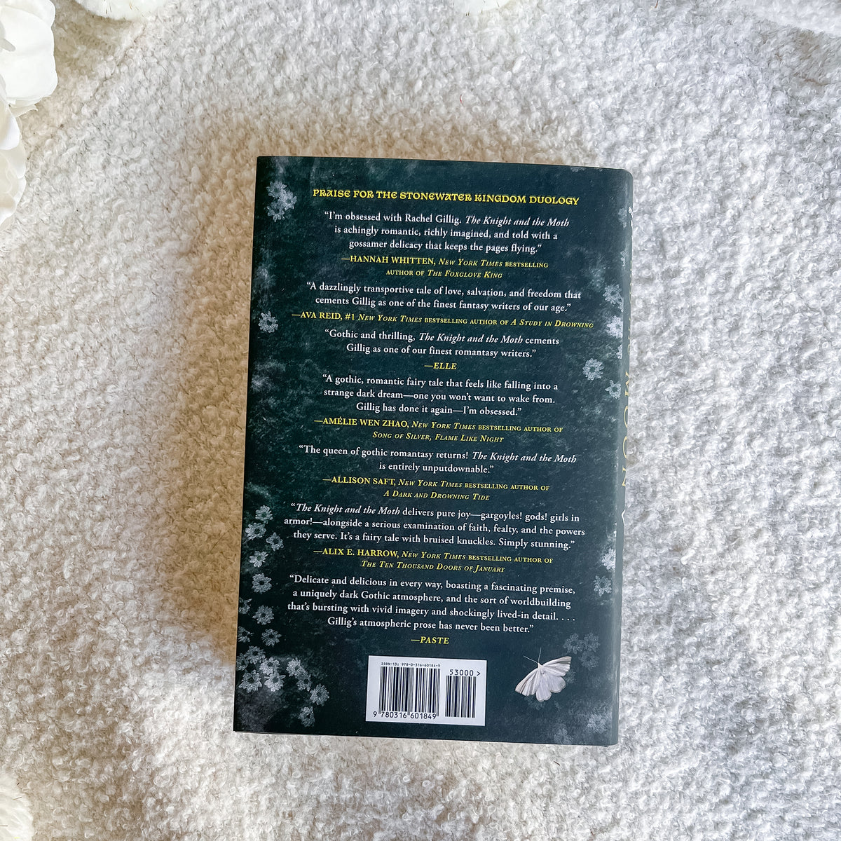 The back cover of a book, photographed flat on a textured white fabric background.