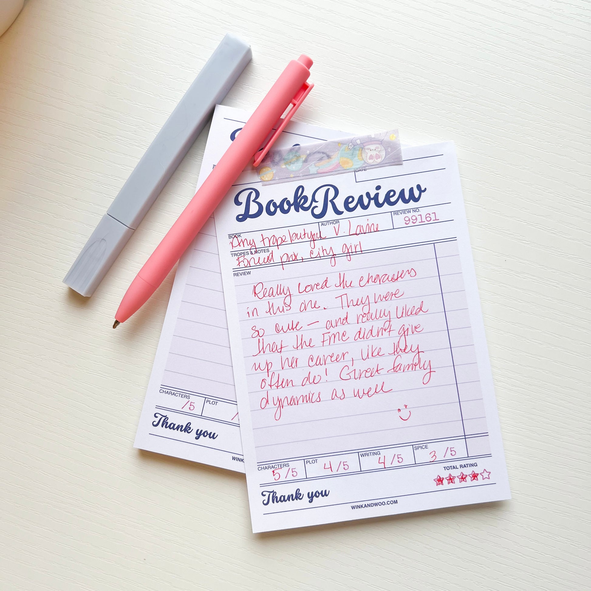 Book review form with a pink pen on a white surface