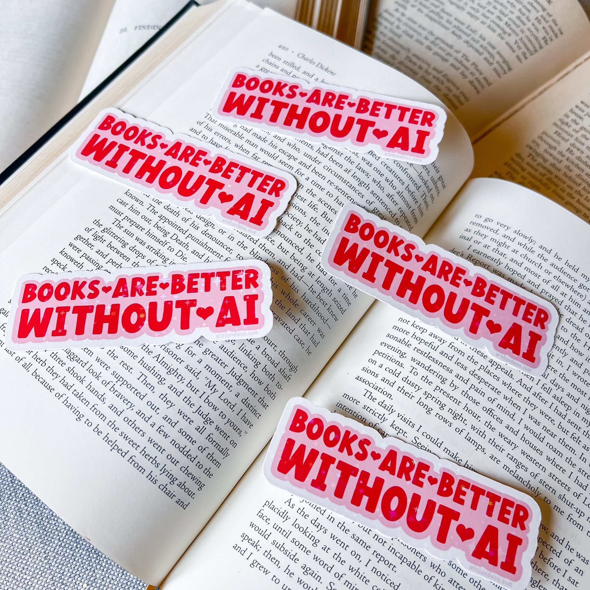 Four 'Books are better without AI' stickers on an open book