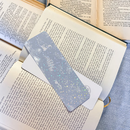 Metallic bookmark on an open book with a blue fabric background