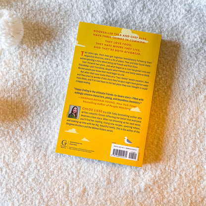 the back of Happy Ending book by Chloe Liese on a light textured background