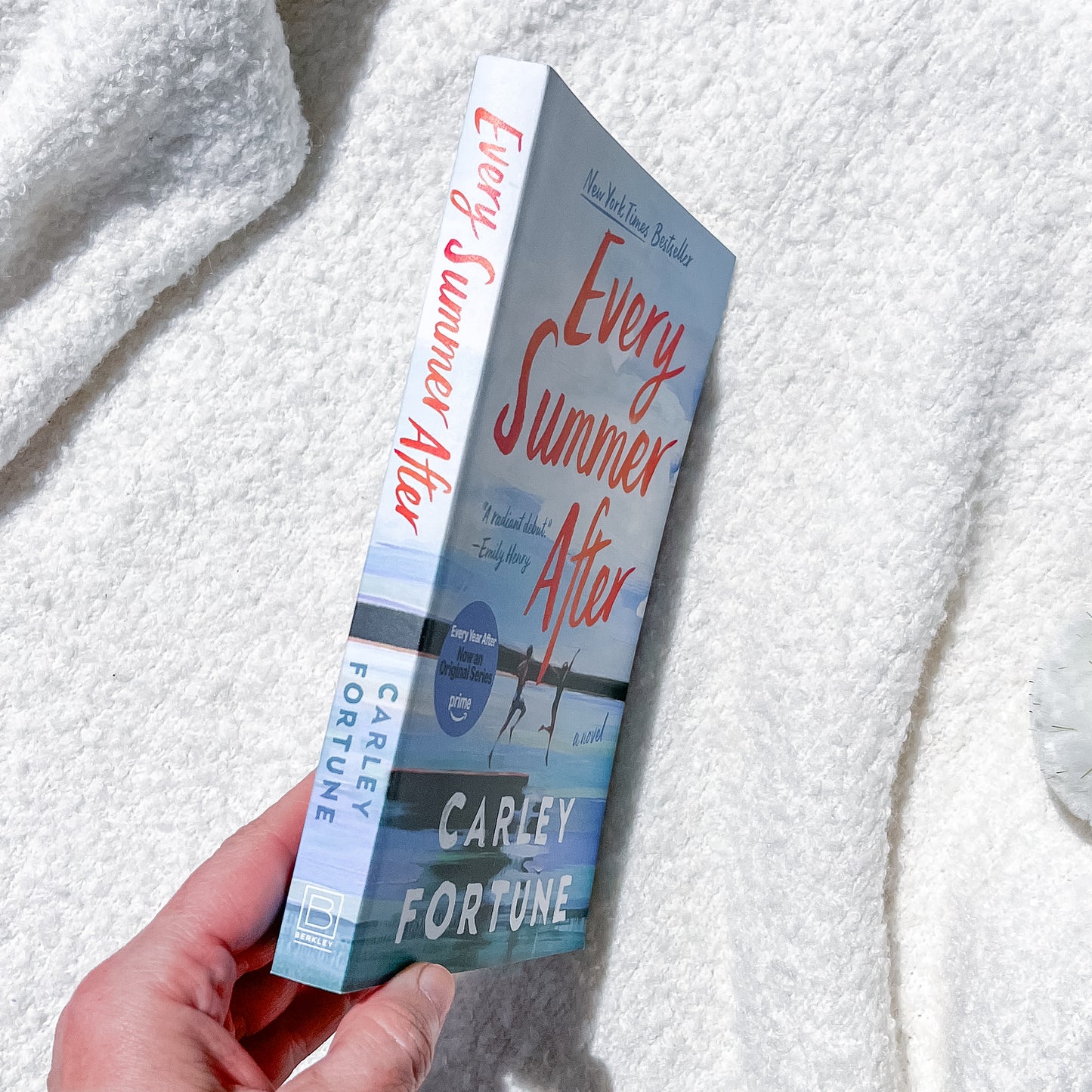 Book titled 'Every Summer After' by Carley Fortune held against a textured white background