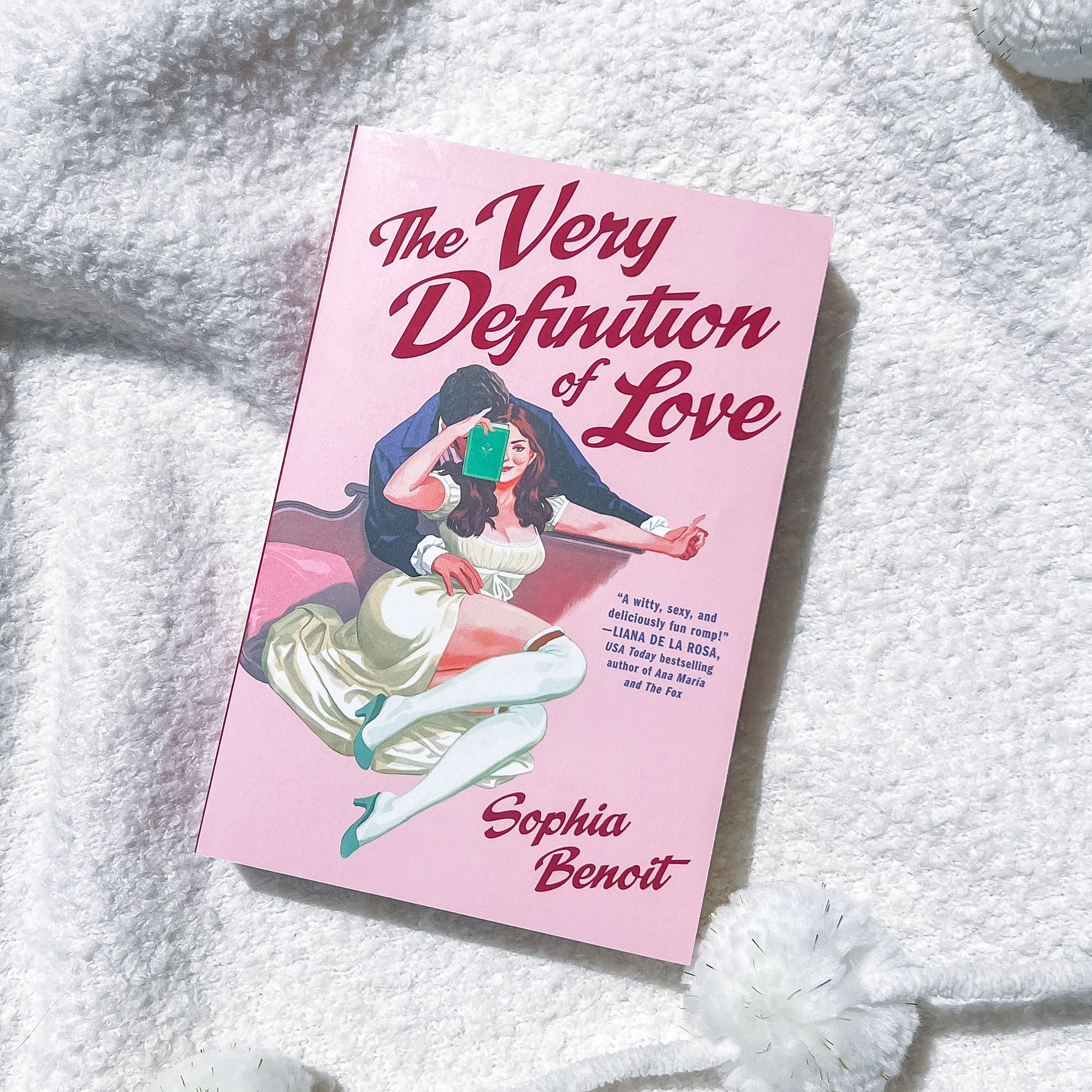 A book, "the very definition of love" by Sophie Benoit, showing a couple embracing on the cover.
