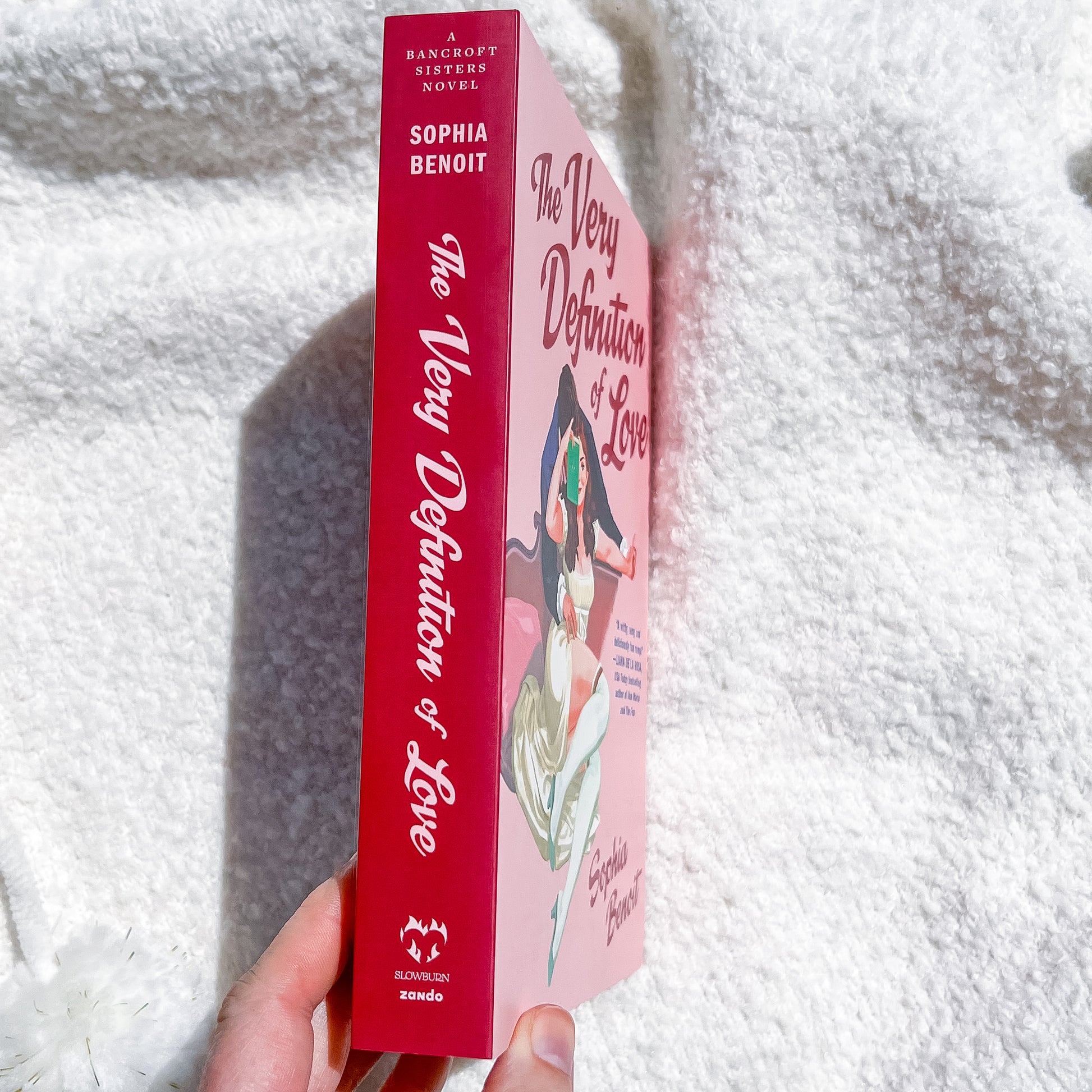 A book, "the very definition of love" by Sophie Benoit, showing a couple embracing on the cover.