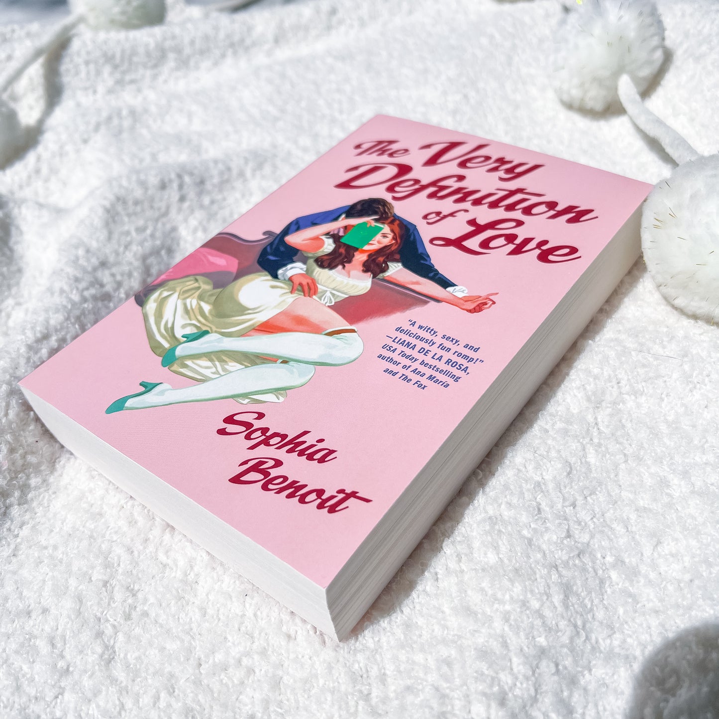 A book, "the very definition of love" by Sophie Benoit, showing a couple embracing on the cover.