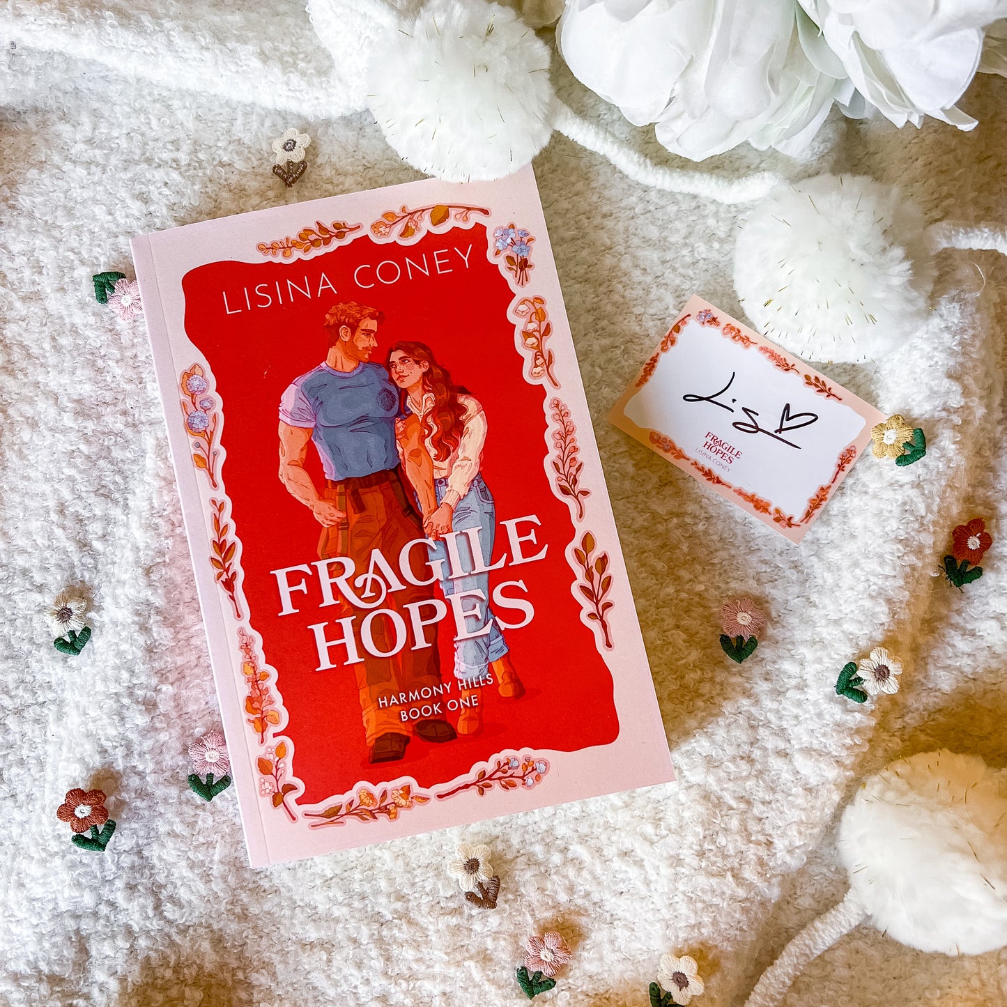 Book titled 'Fragile Hopes' by Lisina Coney on a textured surface with decorative elements.
