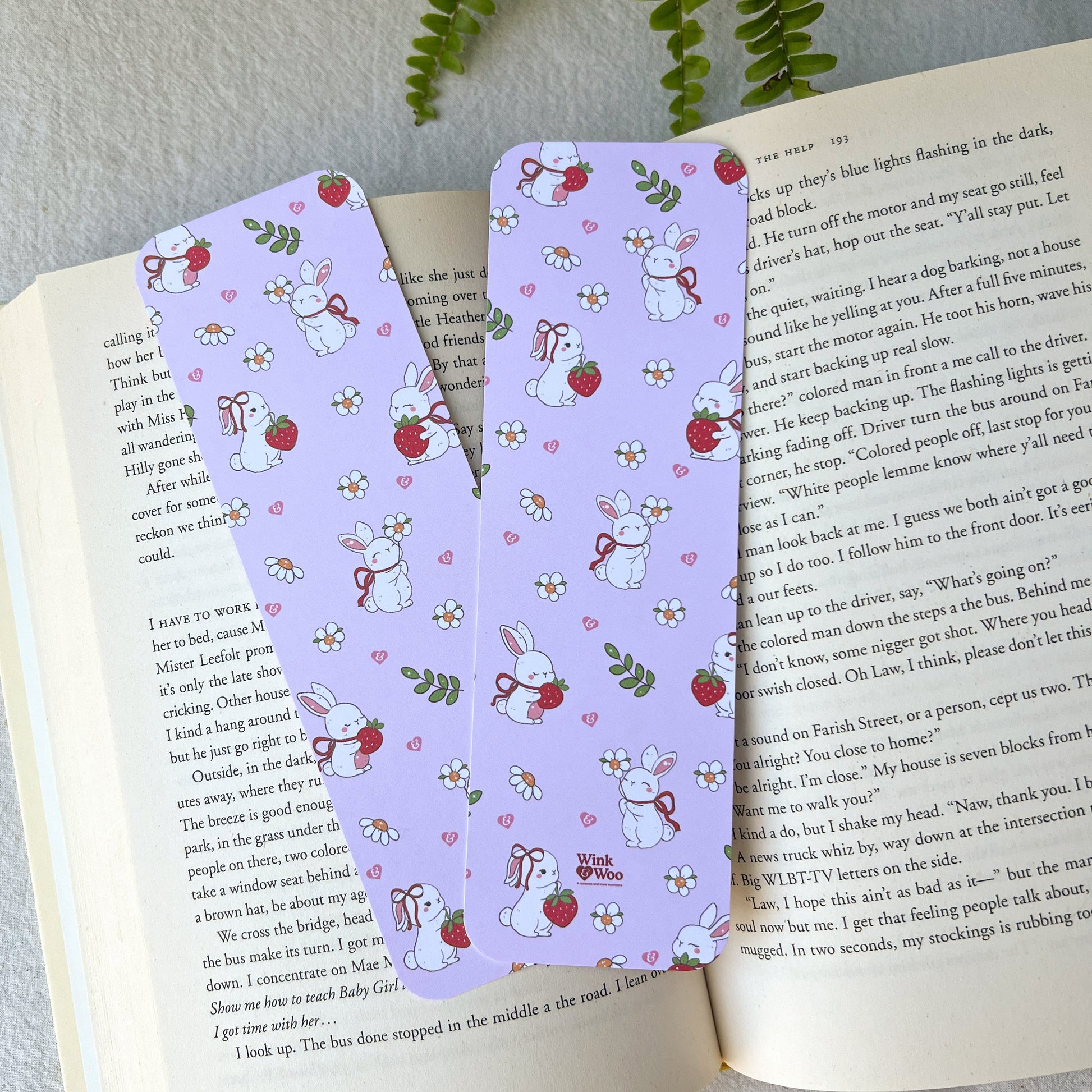 Two pink bookmarks with a bunny design holding berries and flowers.