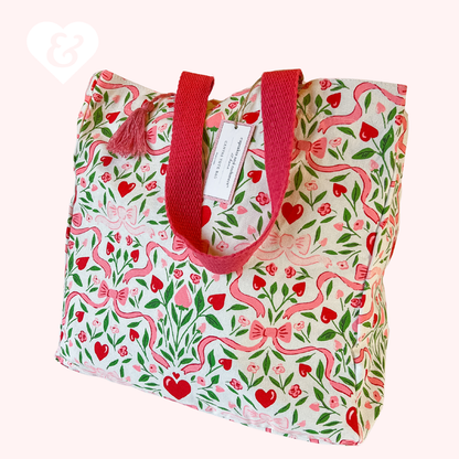 Tote bag with floral pattern and red handles on a white background