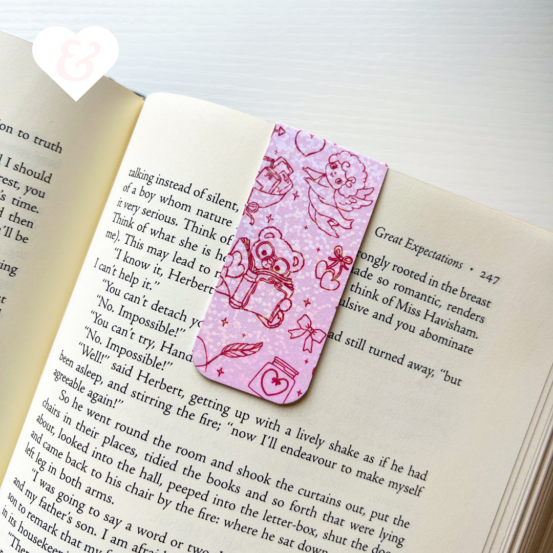 Pink bookmark with teddy bear design on an open book
