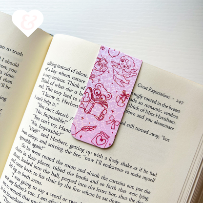 Pink bookmark with teddy bear design on an open book