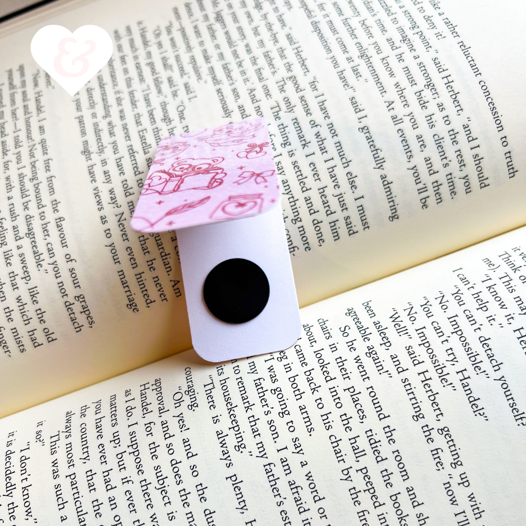 Pink and white bookmark with black center on an open book