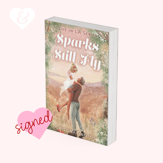 Book titled 'Sparks Still Fly' from the Love in LA Series with a romantic cover and a pink heart with 'signed' text.