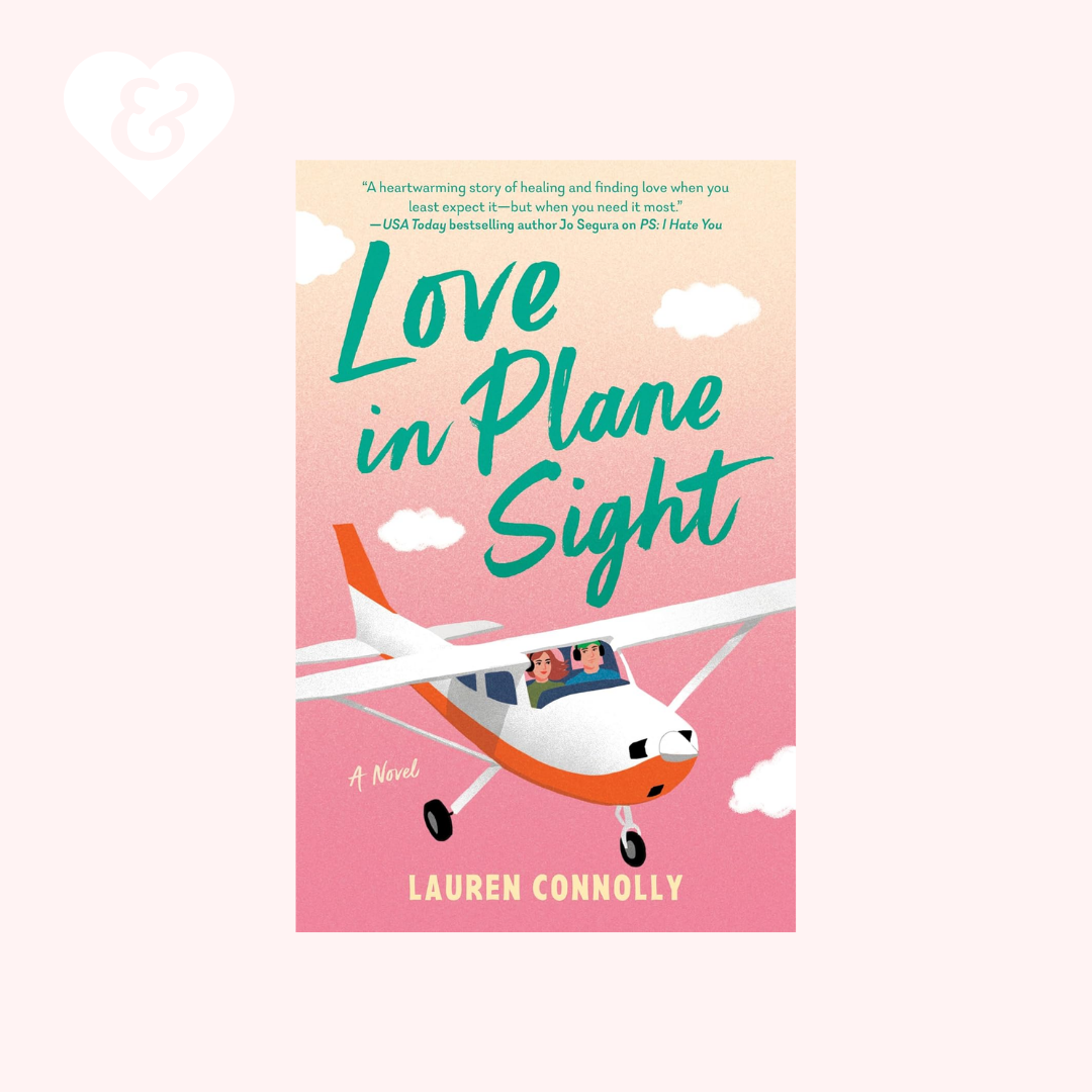 Book cover for the novel 'Love in Plane Sight' by Lauren Connolly, featuring a small orange and white airplane flying against a pink sky with clouds. The cover is centered on a pale pink background with a white heart outline in the upper left corner.