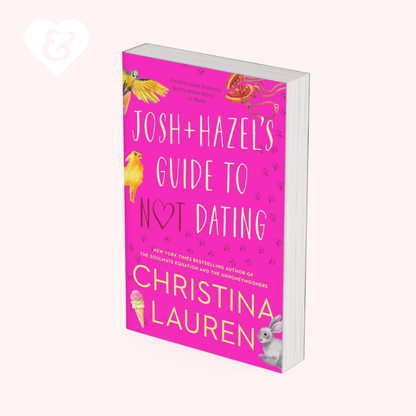 The book cover of 'Josh + Hazel's Guide to Not Dating' by Christina Lauren, shown at a three-quarter angle on a pale pink background. The cover is bright pink with white text and small colorful illustrations of a bird, ice cream cone, and bunny.