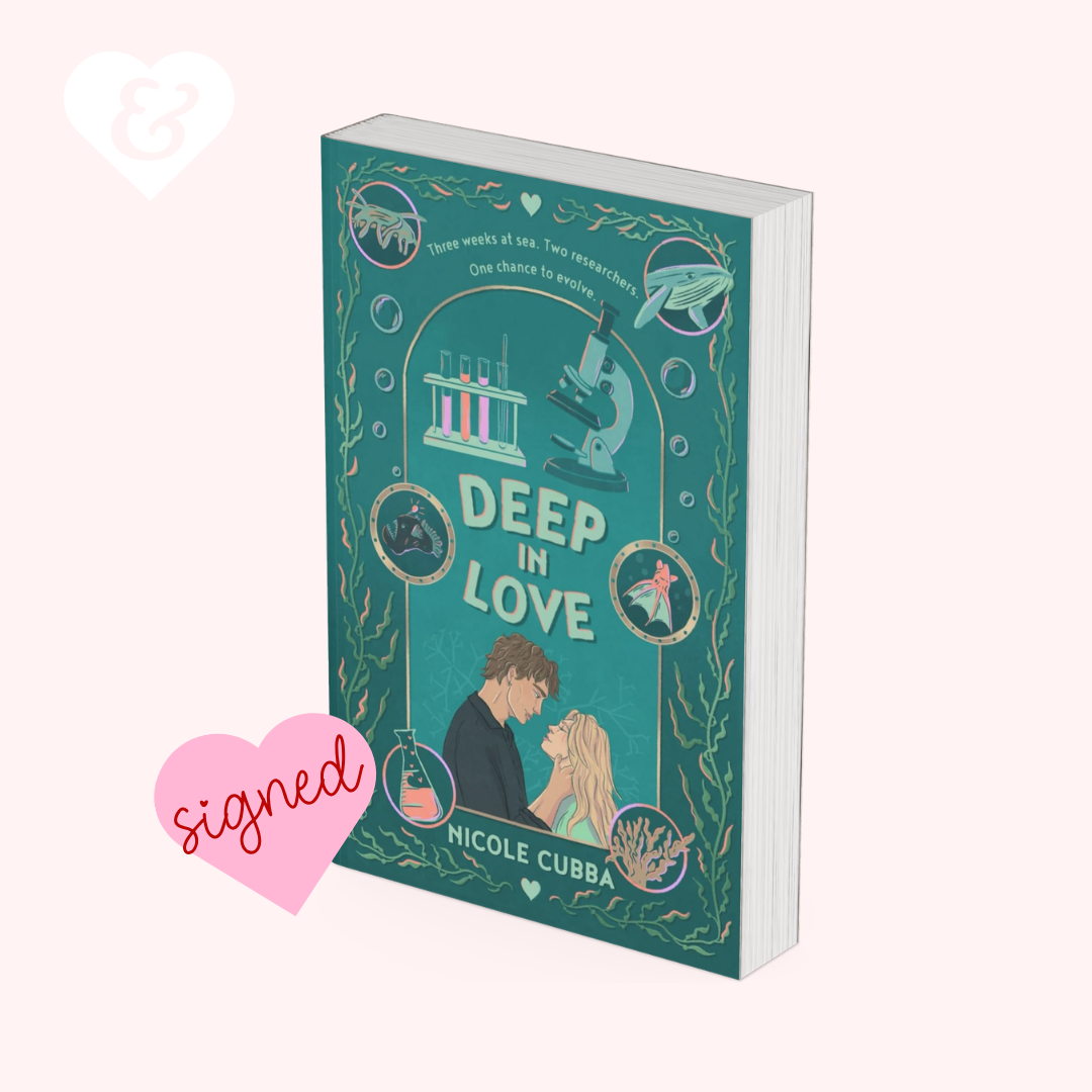 A book cover for 'Deep in Love' by Nicole Cubba, featuring a teal and gold illustration with a couple, a microscope, and scientific motifs, shown on a pale pink background with a pink 'signed' heart graphic and a white ampersand heart icon.
