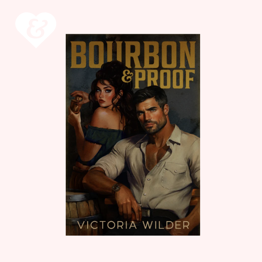 Book cover for 'Bourbon & Proof' by Victoria Wilder, featuring an illustrated man and woman in a dark, romantic setting with gold title text, centered on a pale pink background with a small white heart-and-key icon in the top left.