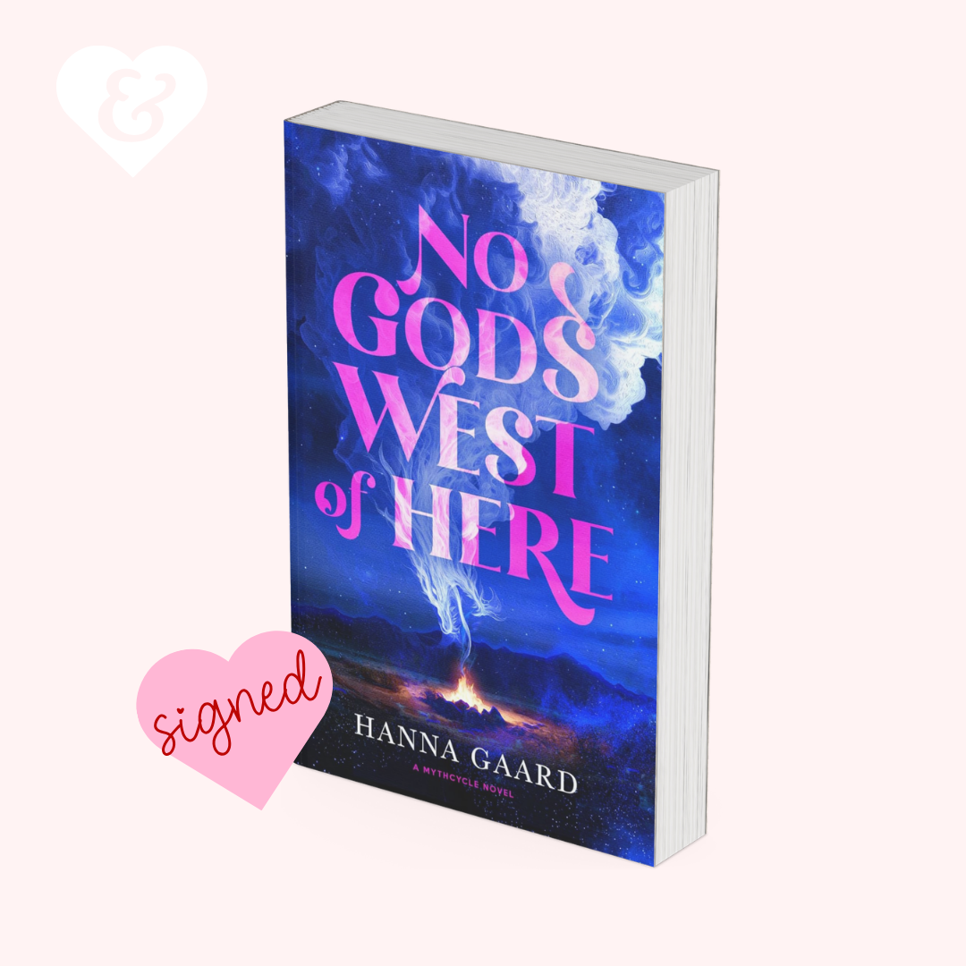A book cover mockup for the novel 'No Gods West of Here' by Hanna Gaard, featuring a dramatic blue and purple sky with lightning and pink title text. The book is shown standing upright on a pale pink background with a pink 'signed' heart graphic and a white ampersand heart in the corner.