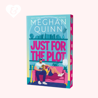 Book cover for 'Just for the Plot' by Meghan Quinn, featuring a colorful illustration of a couple on a pink couch. The book is shown at a slight angle against a pale pink background with a small white heart logo in the top-left corner.