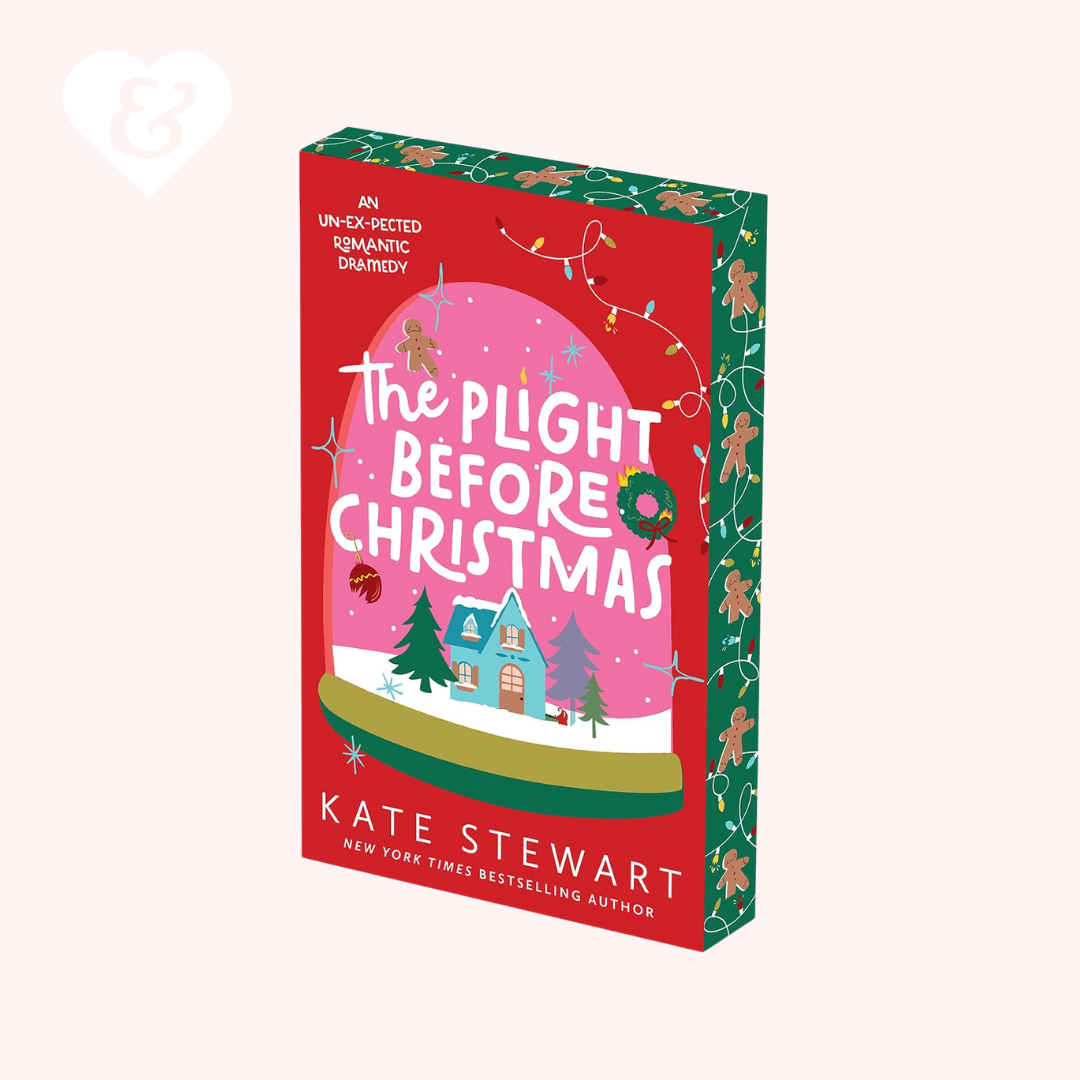 The book cover of 'The Plight Before Christmas' by Kate Stewart, featuring a festive red and green holiday design with a pink snow globe illustration, shown on a pale pink background.