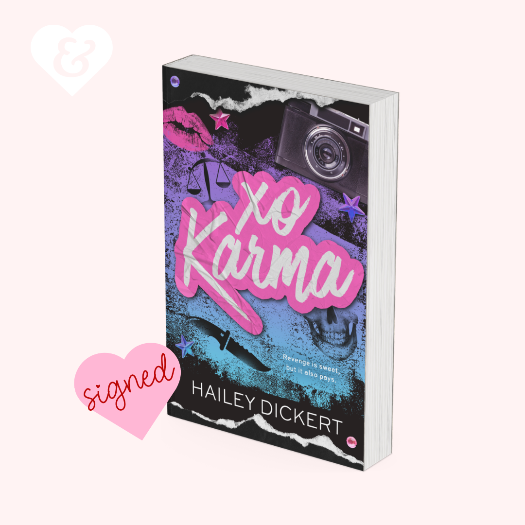 A signed copy of the book 'Xo Karma' by Hailey Dickert, shown at an angle on a pale pink background with a pink 'signed' heart graphic and a white ampersand heart icon.