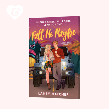 A 3D mockup of a book cover titled 'Fall Me Maybe' by Laney Hatcher, featuring an illustration of a young couple standing in front of a blue jeep on a road with a sunset sky. The book is displayed against a solid pale pink background.