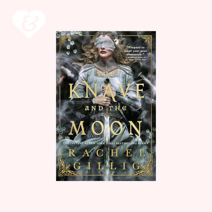 Book cover for 'The Knave and the Moon' by Rachel Gillig, featuring a blindfolded woman in a pale blue gown against a dark smoky background with gold title text and ornate gold border details, centered on a light pink background.