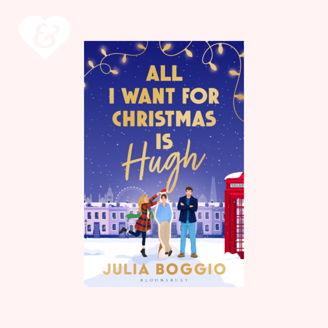 Book cover for 'All I Want For Christmas Is Hugh' by Julia Boggio, featuring a festive winter city scene with three illustrated characters, a red telephone booth, and gold title text on a dark blue background.