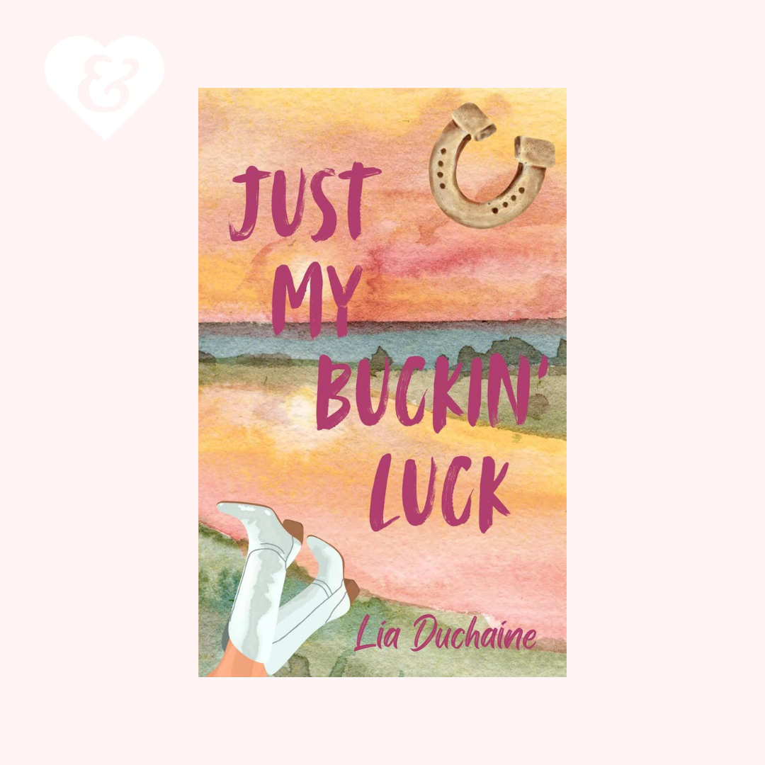 A book cover for 'Just My Buckin' Luck' by Lia Duchaine, featuring a watercolor sunset landscape with pink and orange tones, a horseshoe at the top right, white cowboy boots at the bottom left, and the title in pink lettering.