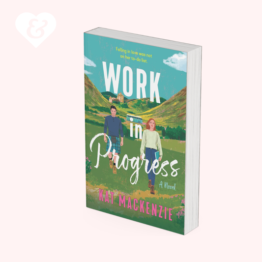 A 3D mockup of a paperback book titled 'Work in Progress' by Wat McKenzie, featuring a colorful illustrated cover with a couple walking in a field, set against a solid pale pink background.