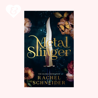 Book cover for 'Metal Slinger' by Rachel Schneider, featuring a vertical dagger with a silver blade and a purple handle against a dark blue background with gold lettering, surrounded by roses and a butterfly. The book is centered on a pale pink background with a small white heart-and-key icon in the top-left corner.