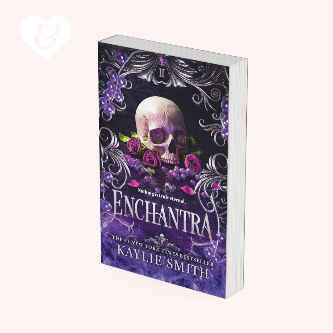 The book cover of 'Enchantra' by Kaylie Smith, featuring a gothic design with a skull, purple roses, and grapes on a dark background, shown as a 3D mockup on a pale pink background.