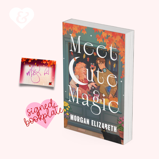 Book cover for 'Meet Cute Magic' by Morgan Elizabeth, shown upright with a small autographed bookplate and a heart-shaped logo on a pale pink background.