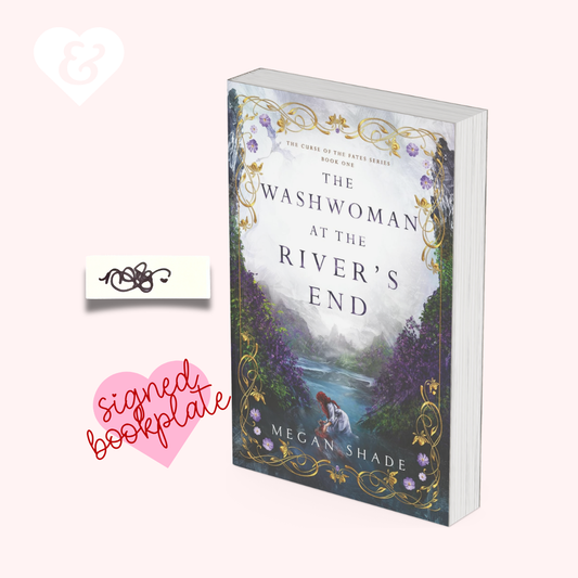 The book 'The Washwoman at the River's End' by Megan Shade is shown standing upright on a pale pink background, alongside a white heart icon, a small decorative sticker, and a pink heart-shaped 'signed bookplate' graphic.