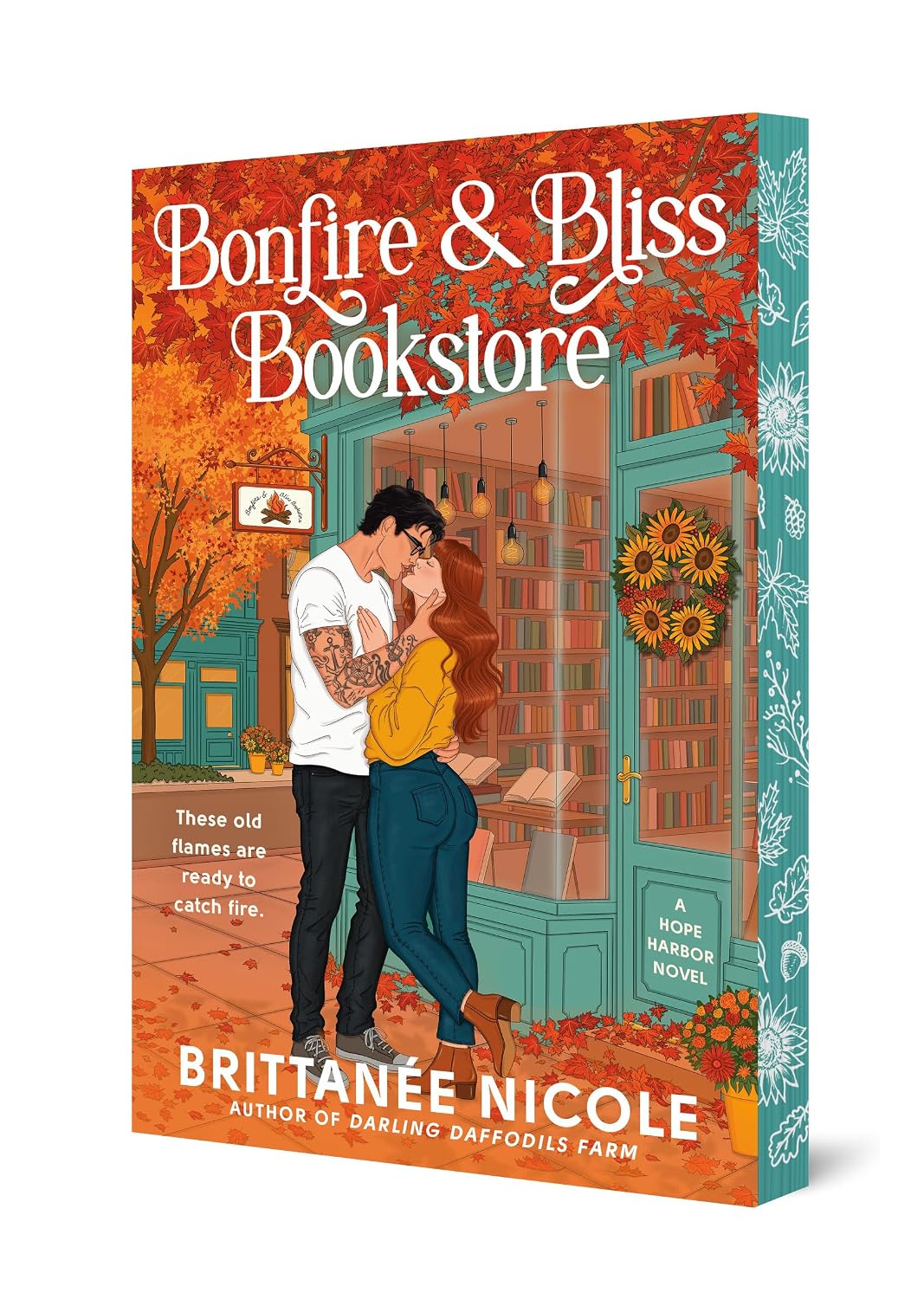 Book cover of 'Bonfire & Bliss Bookstore' by Brittanee Nicole with a couple embracing in front of a bookstore.