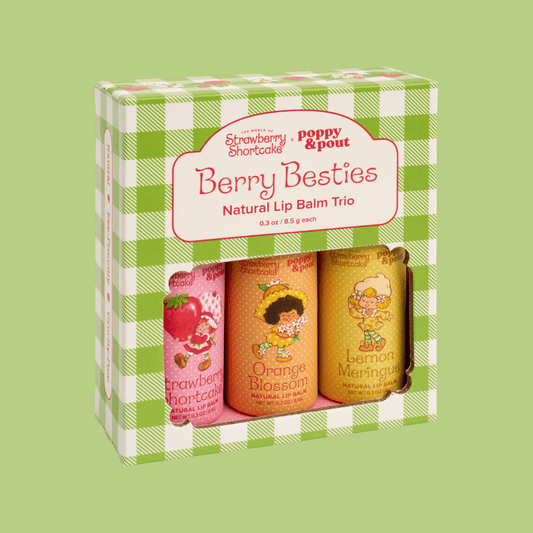 Strawberry Shortcake x Poppy & Pout Berry Besties Natural Lip Balm Trio in a green and white checkered box, showing three lip balms inside: Strawberry Shortcake, Orange Blossom, and Lemon Meringue.