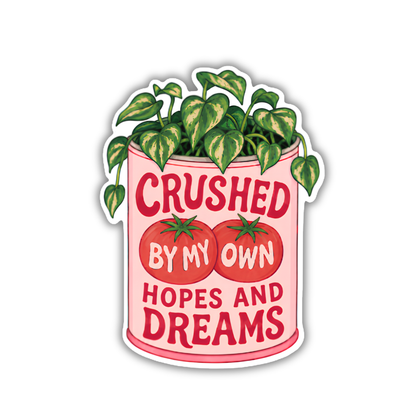 A die-cut sticker featuring a pink planter with green leafy vines growing out of it, two red tomatoes, and the text 'CRUSHED BY MY OWN HOPES AND DREAMS' on a white background.
