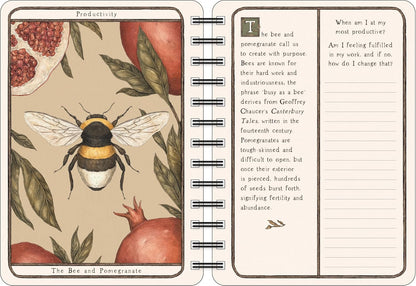 An open spiral-bound notebook showing a vintage-style illustrated page titled 'Productivity' with a bee and pomegranate, alongside a lined writing page with text about bees and pomegranates.
