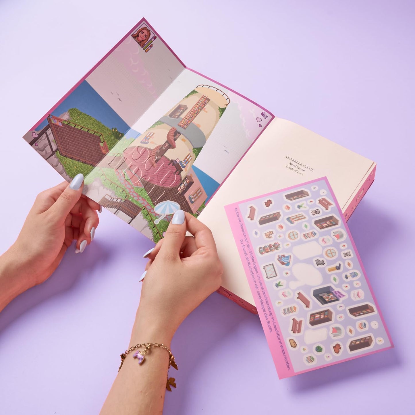 Open notebook with illustrated pages and a set of stickers on a light purple background