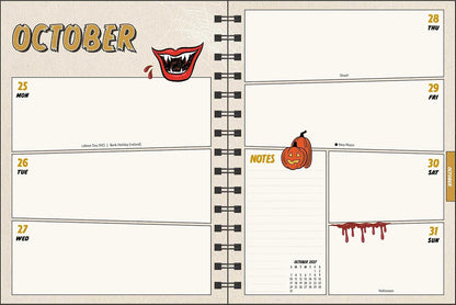 An open spiral-bound planner showing a October weekly layout with six daily boxes, a notes section, a small calendar, and Halloween-themed illustrations including a smiling mouth and a pumpkin.